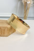 Gold-tone wide bracelet featuring a smooth rounded band on a white studio background