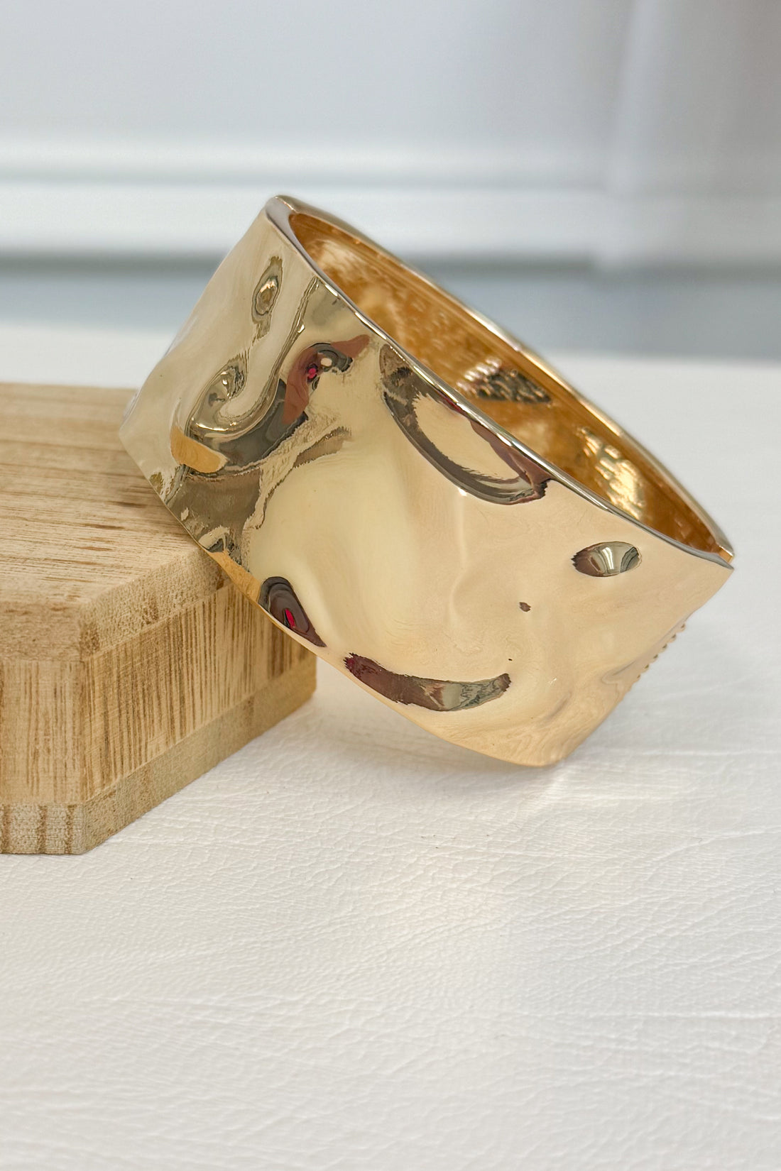 Gold-tone bracelet featuring an organic textured design with raised detailing throughout the band on a white studio background