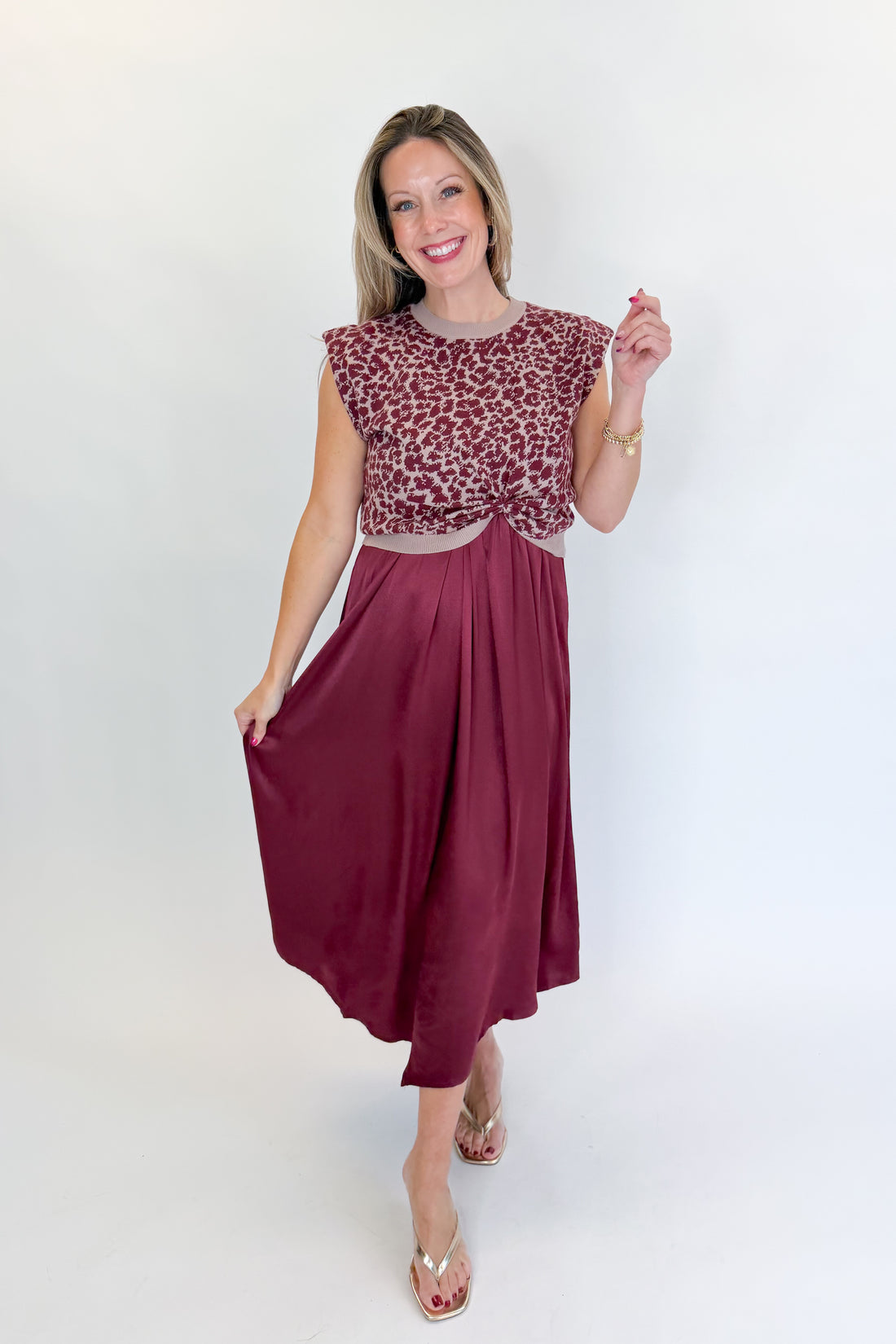 Front view of woman wearing Swagger Boutique’s Wine &amp; Leopard Layered Midi Dress with heels against white studio background.