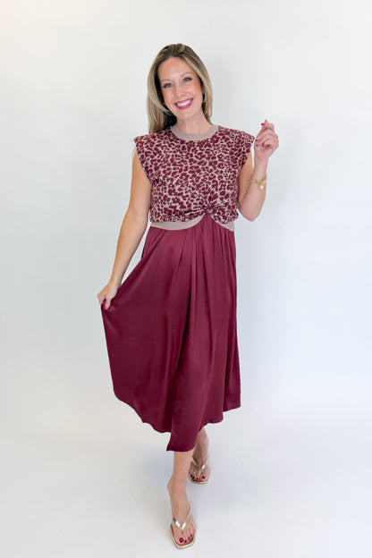 Front view of woman wearing Swagger Boutique’s Wine &amp; Leopard Layered Midi Dress with heels against white studio background.
