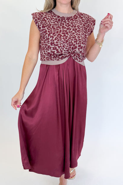 Front detail view of woman wearing Swagger Boutique’s Wine &amp; Leopard Layered Midi Dress with heels against white studio background.