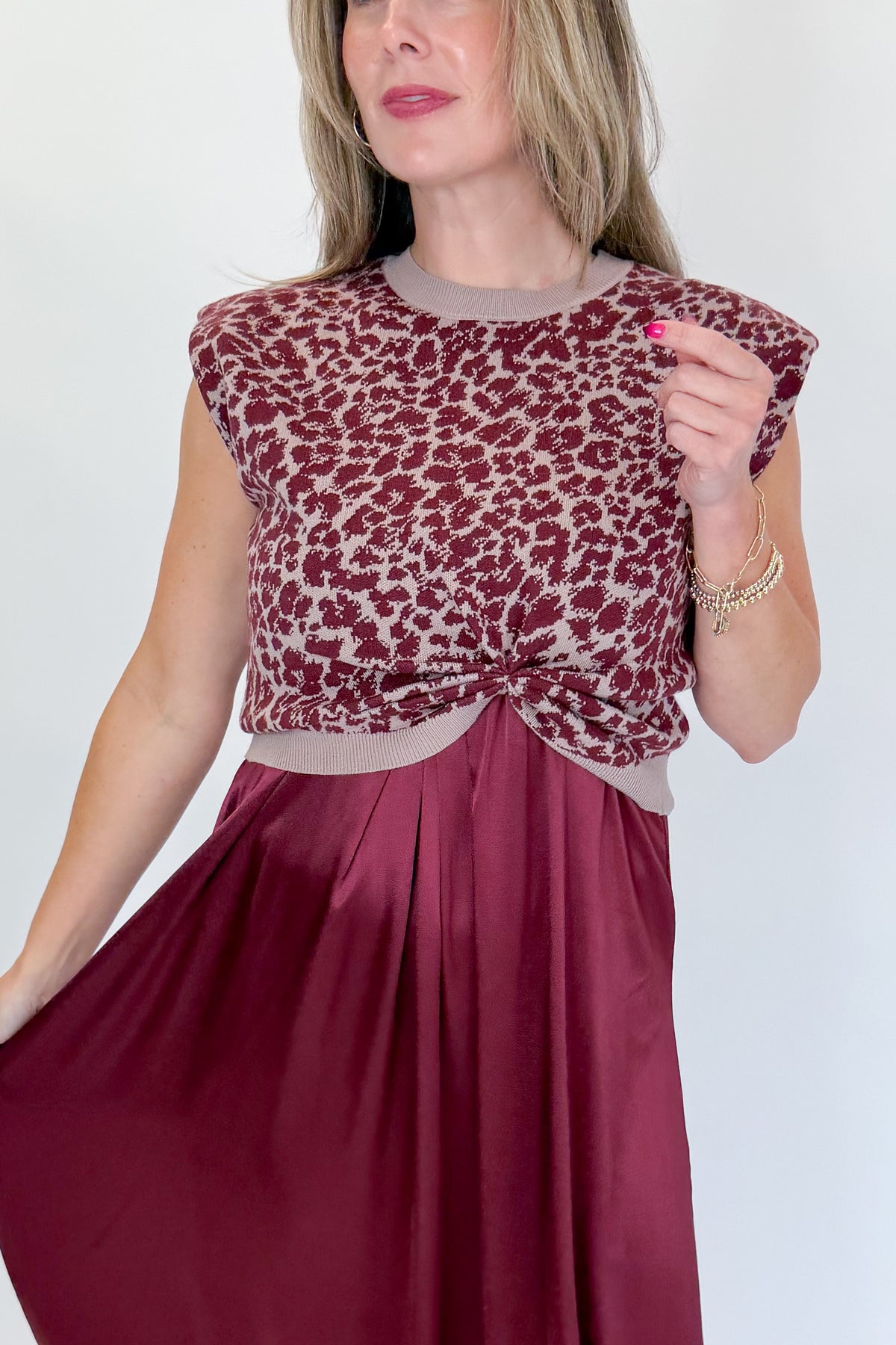 Front detail view of woman wearing Swagger Boutique’s Wine &amp; Leopard Layered Midi Dress with heels against white studio background.