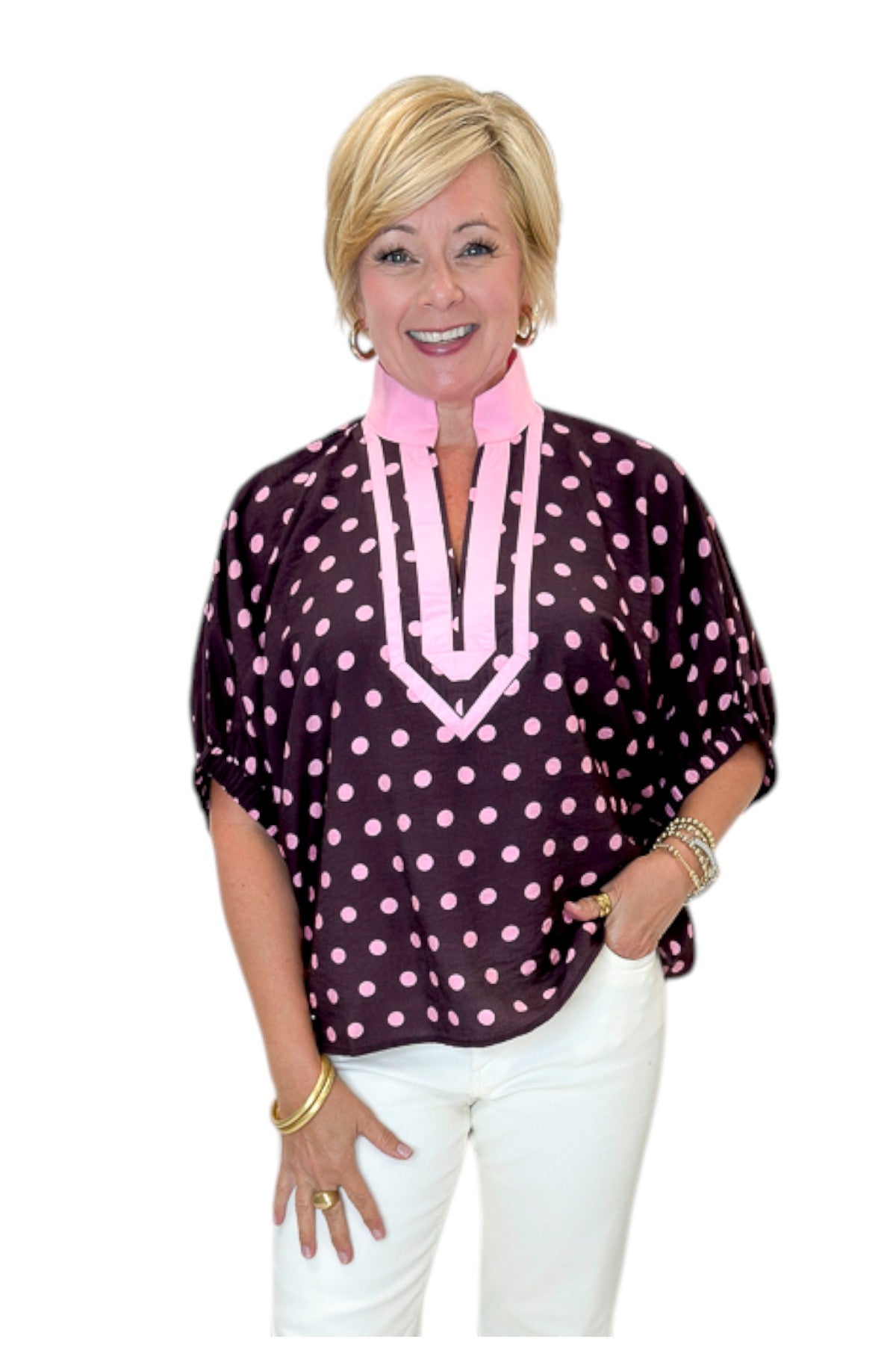 Front view of woman wearing Swagger Boutique’s Wine &amp; Pink Polka Dot Dolman Sleeve Top by Entro with jeans against white studio background.
