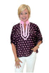Front view of woman wearing Swagger Boutique’s Wine & Pink Polka Dot Dolman Sleeve Top by Entro with jeans against white studio background.