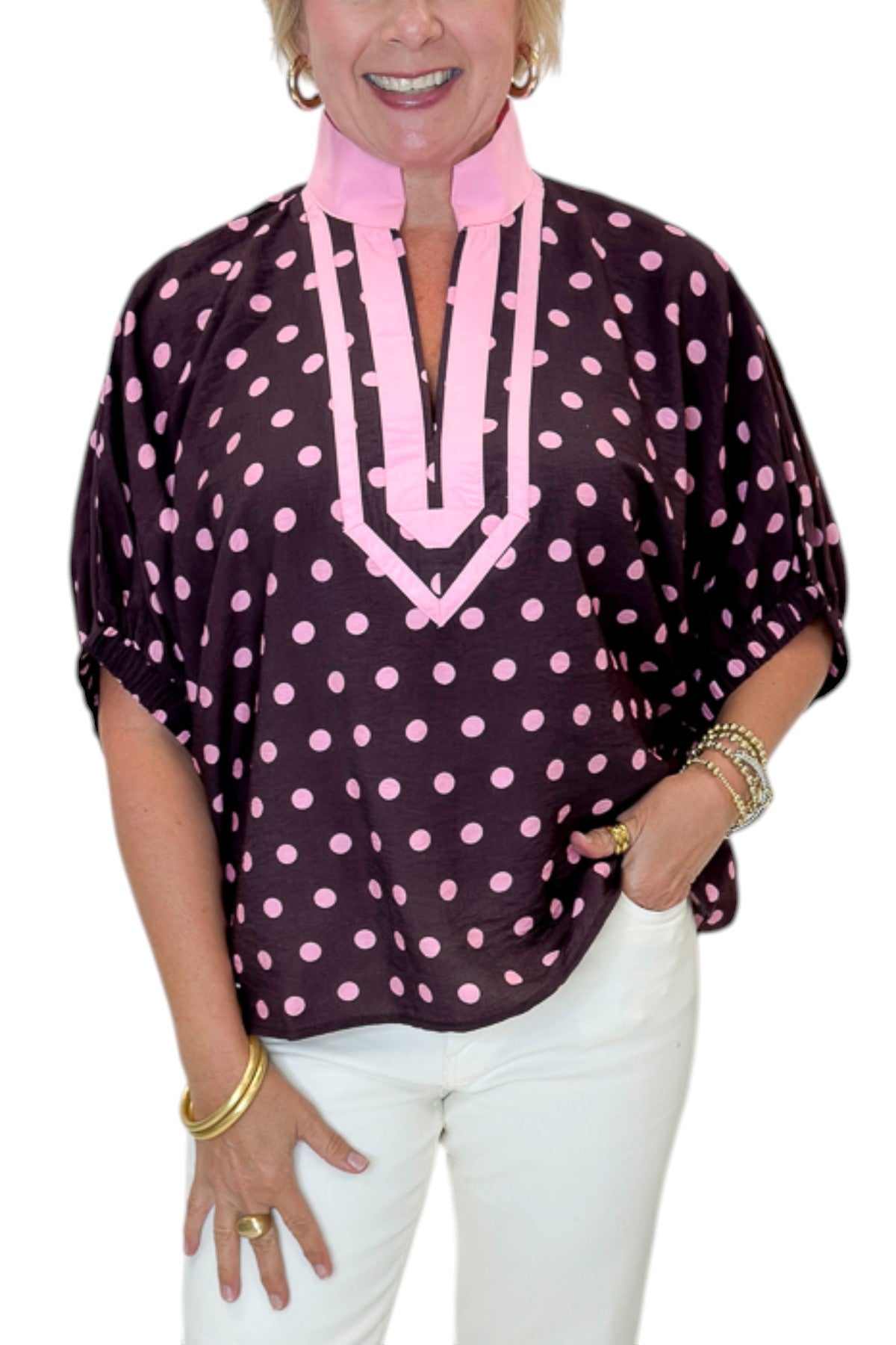 Front detail view of woman wearing Swagger Boutique’s Wine &amp; Pink Polka Dot Dolman Sleeve Top by Entro with jeans against white studio background.