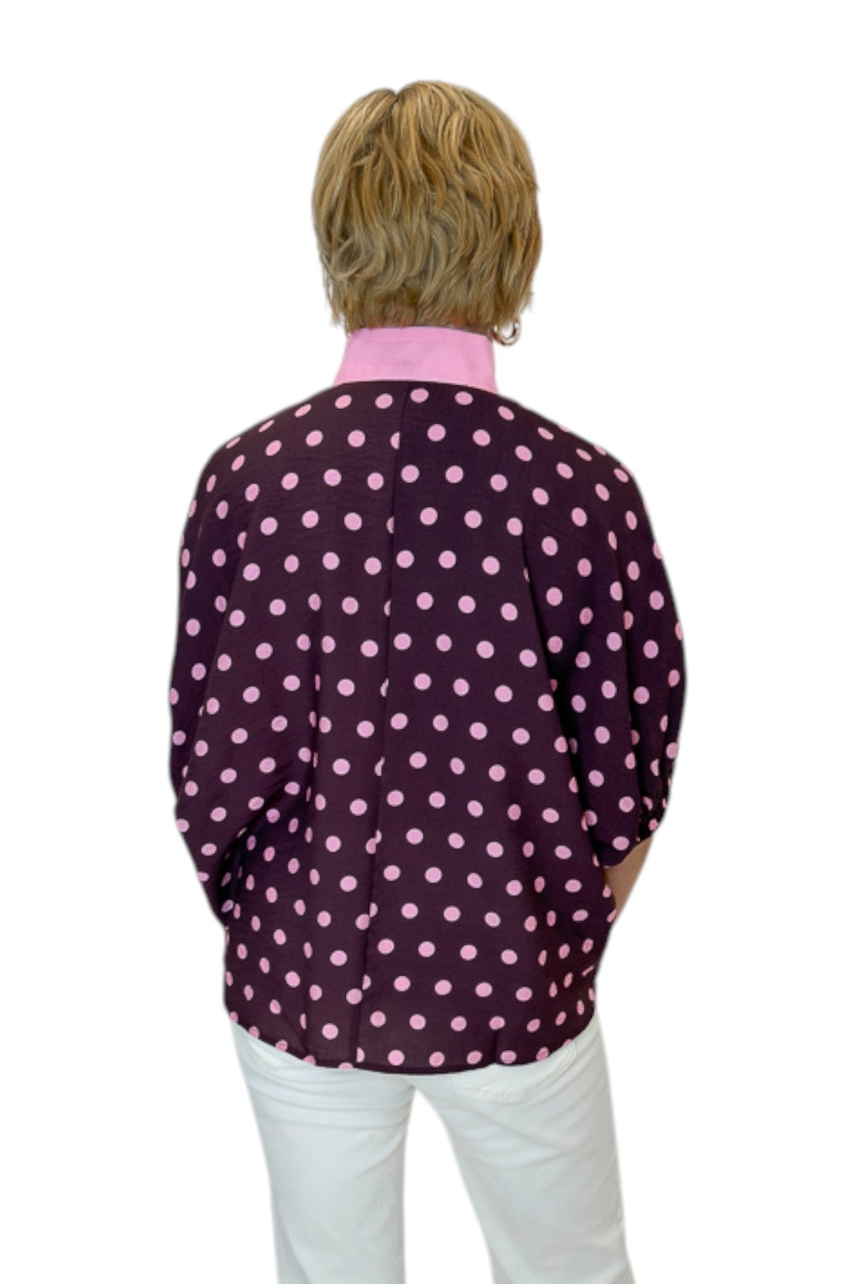 Back view of woman wearing Swagger Boutique’s Wine &amp; Pink Polka Dot Dolman Sleeve Top by Entro with jeans against white studio background.