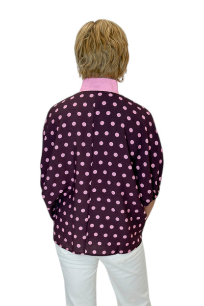 Back view of woman wearing Swagger Boutique’s Wine &amp; Pink Polka Dot Dolman Sleeve Top by Entro with jeans against white studio background.