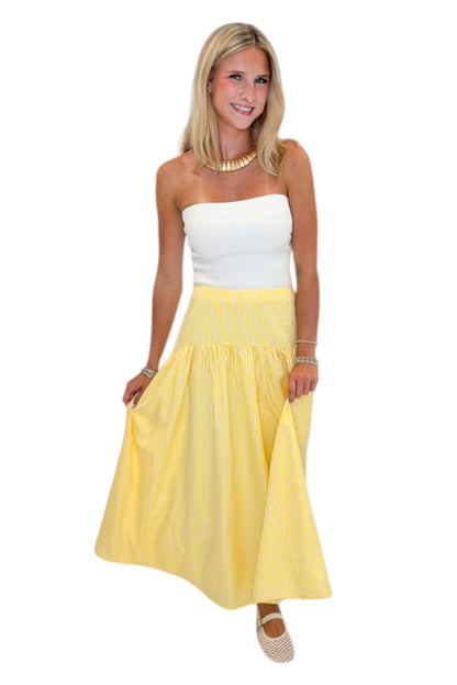 Front view of woman wearing Swagger Boutique’s Yellow Gingham Skirt with white top against white studio background.