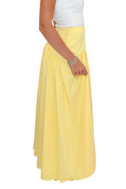Side detail view of woman wearing Swagger Boutique’s Yellow Gingham Skirt with white top against white studio background.