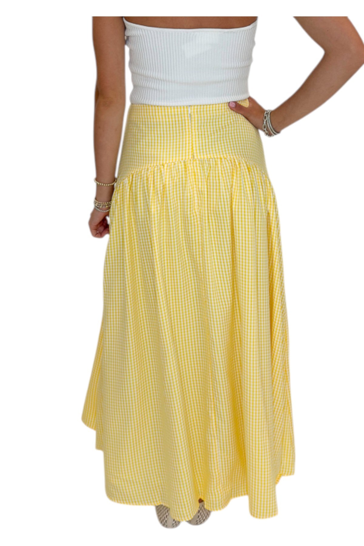 Back view of woman wearing Swagger Boutique’s Yellow Gingham Skirt with white top against white studio background.
