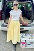 Front view of woman wearing Swagger Boutique’s Yellow Gingham Skirt with white top at a football tailgate.