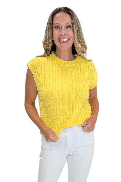 Front view of woman wearing Swagger Boutique’s Yellow Ribbed Detail Sleeveless Sweater by Entro with jeans against white studio background.