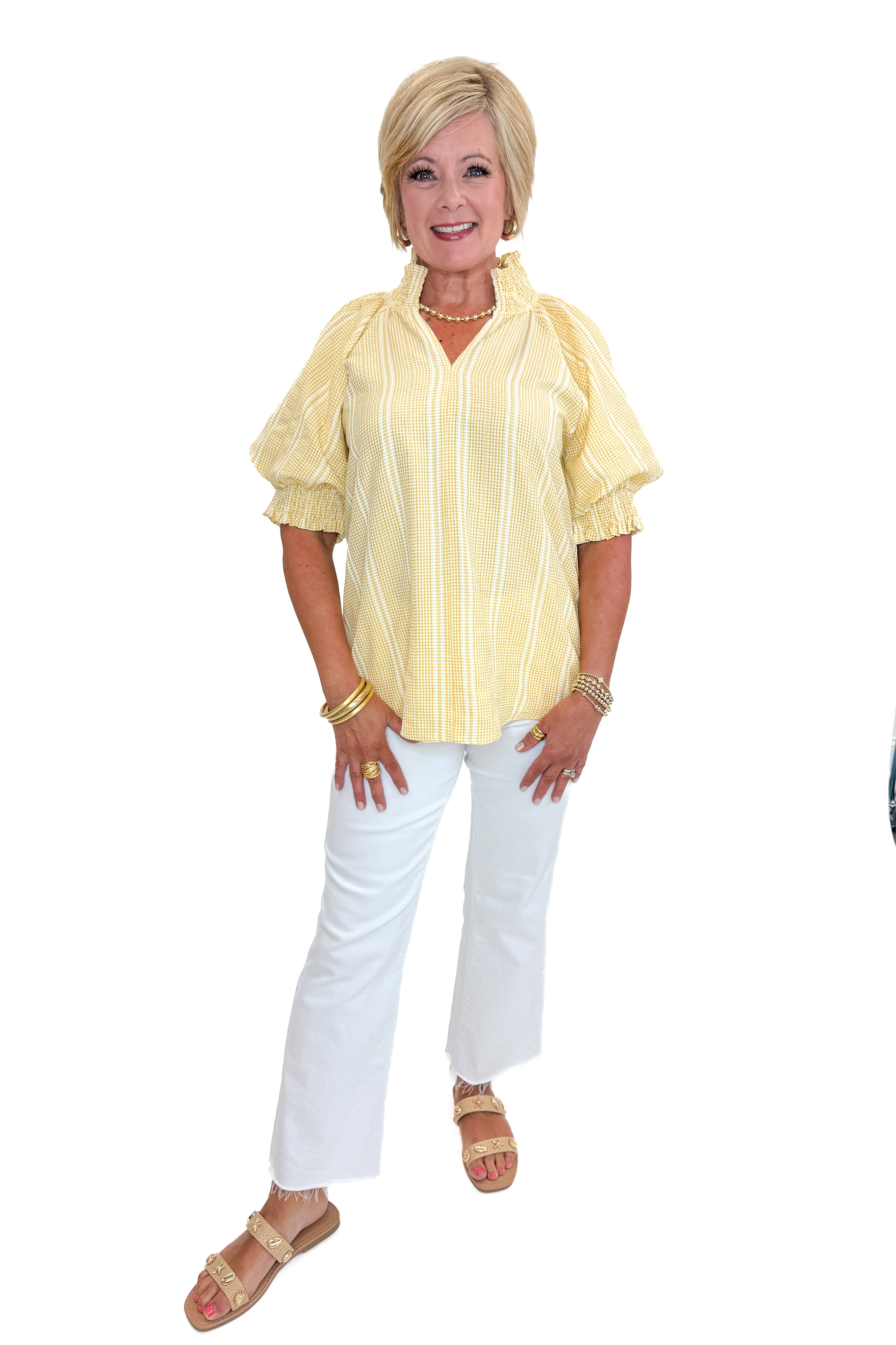 Front view of woman wearing Swagger Boutique’s Yellow Striped Puff Sleeve Top with jeans against white studio background.