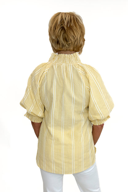Back view of woman wearing Swagger Boutique’s Yellow Striped Puff Sleeve Top with jeans against white studio background.