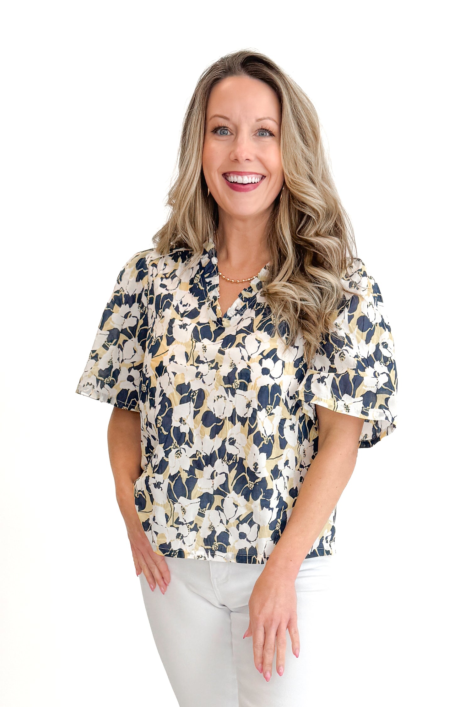 Front view of woman wearing Swagger Boutique’s Yellow &amp; Navy Floral Printed Top with jeans against white studio background.