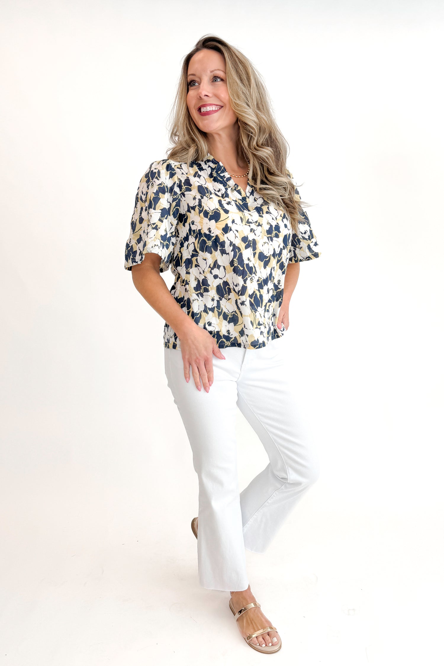 Front view of woman wearing Swagger Boutique’s Yellow &amp; Navy Floral Printed Top with jeans against white studio background.