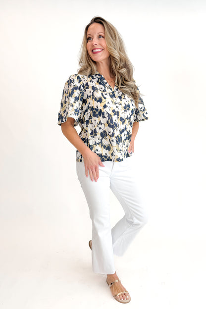 Front view of woman wearing Swagger Boutique’s Yellow &amp; Navy Floral Printed Top with jeans against white studio background.