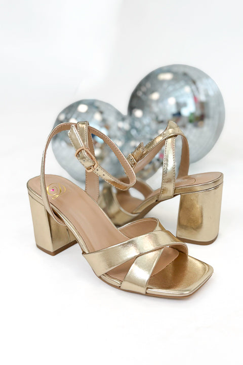 Yule- Gold Cross Strap Heels against white studio background.