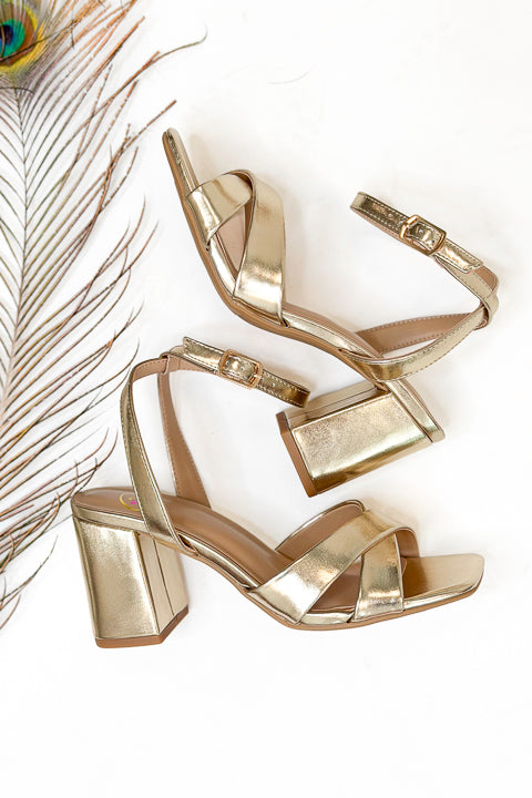 Yule- Gold Cross Strap Heels against white studio background.