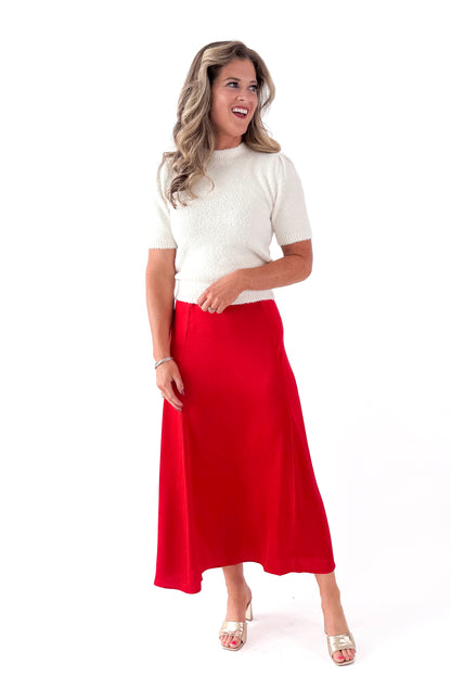 Front view of woman wearing cream top with Festive Red Northpointe Midi Skirt against white studio background.