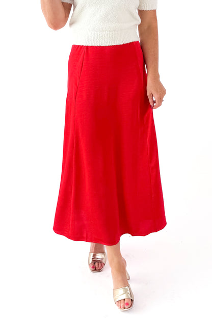 Front detailed view of woman wearing cream top with Festive Red Northpointe Midi Skirt against white studio background.
