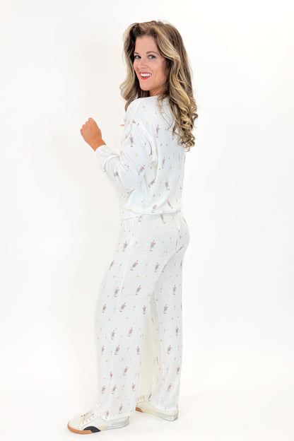 Side view of woman wearing Vanilla Ice Dawn Champagne Lounge Pants with matching top against white studio background.