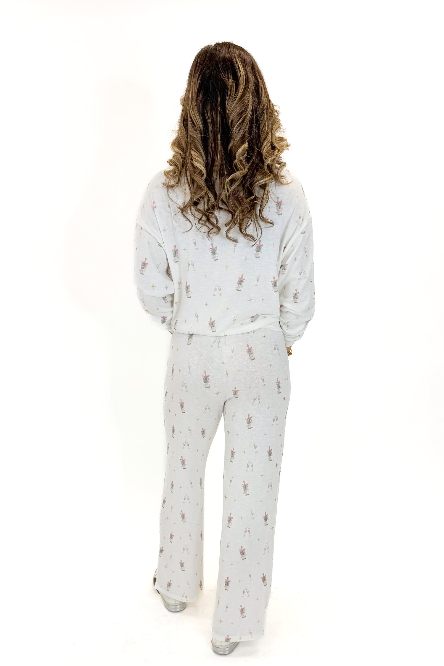 Back view of woman wearing Vanilla Ice Dawn Champagne Lounge Pants with matching top against white studio background.