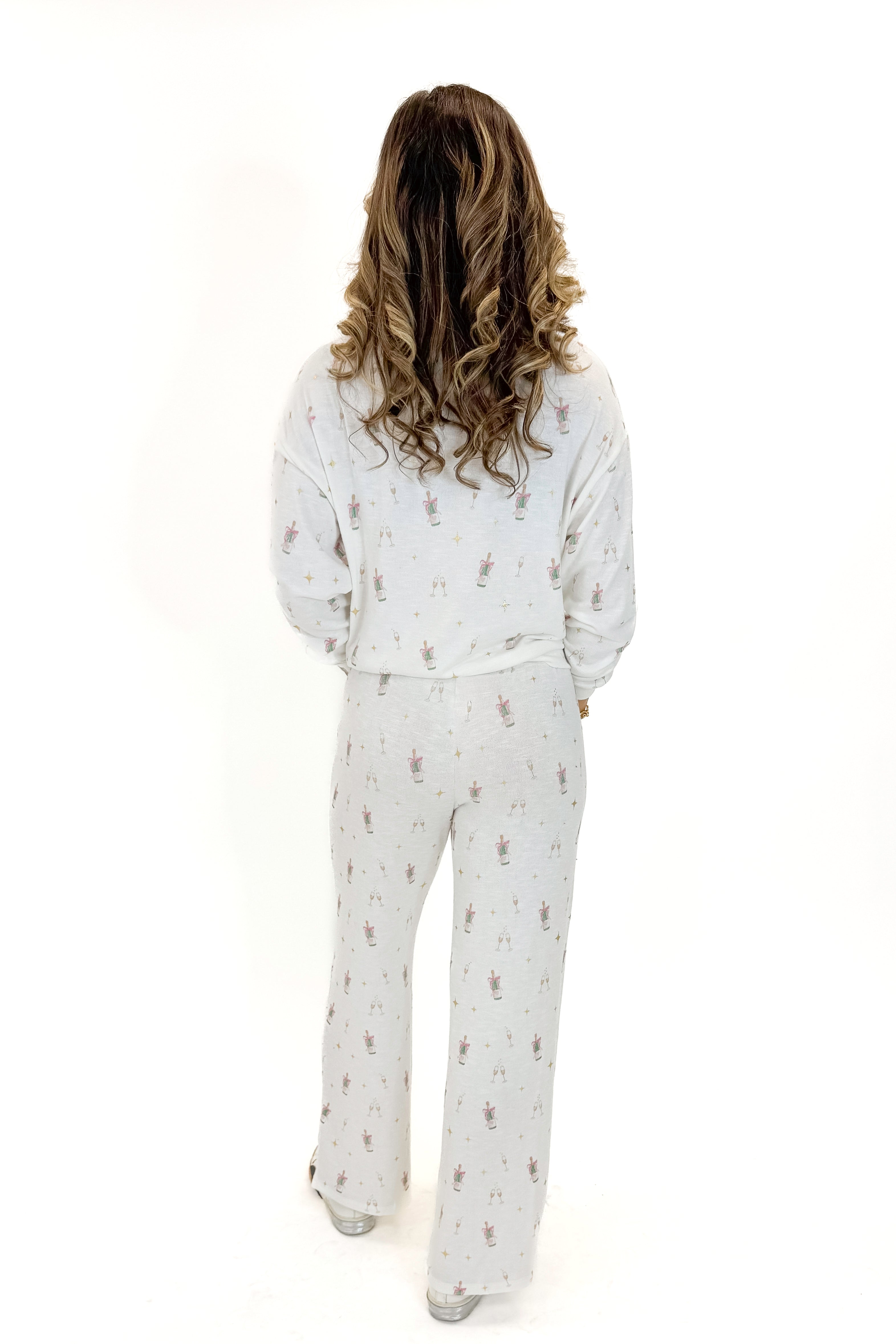 Back view of woman wearing Vanilla Ice Dawn Champagne Lounge Pants with matching top against white studio background.