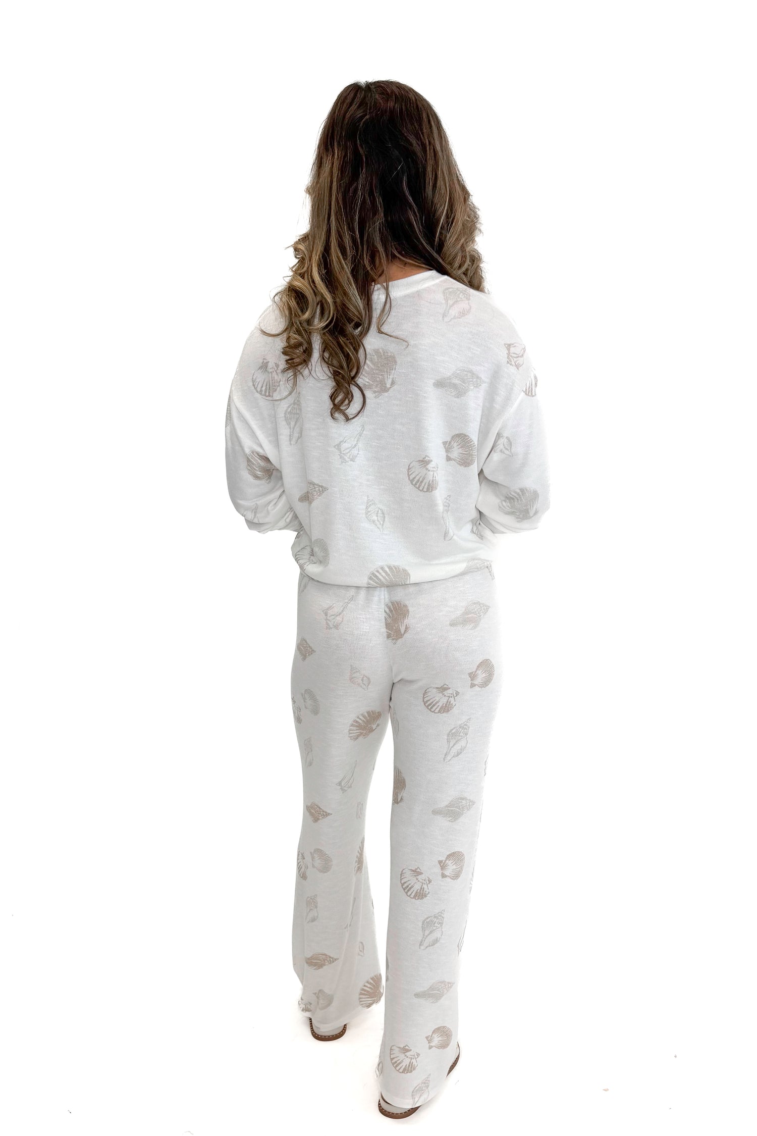 Back view of woman wearing Vanilla Ice So Sweet Shell Pants by Z Supply with matching top against white studio background.