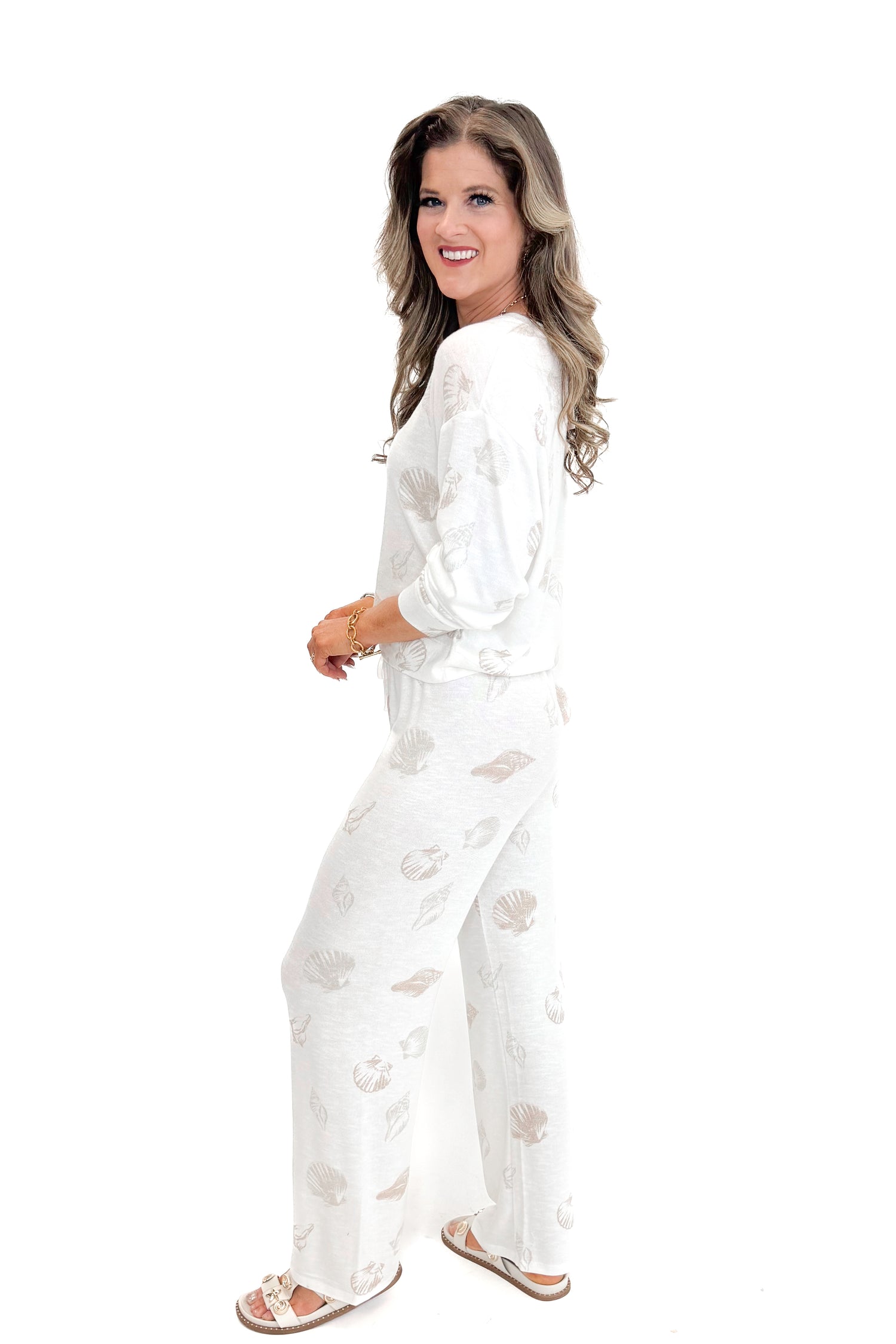 Side view of woman wearing Vanilla Ice So Sweet Shell Pants by Z Supply with matching top against white studio background.