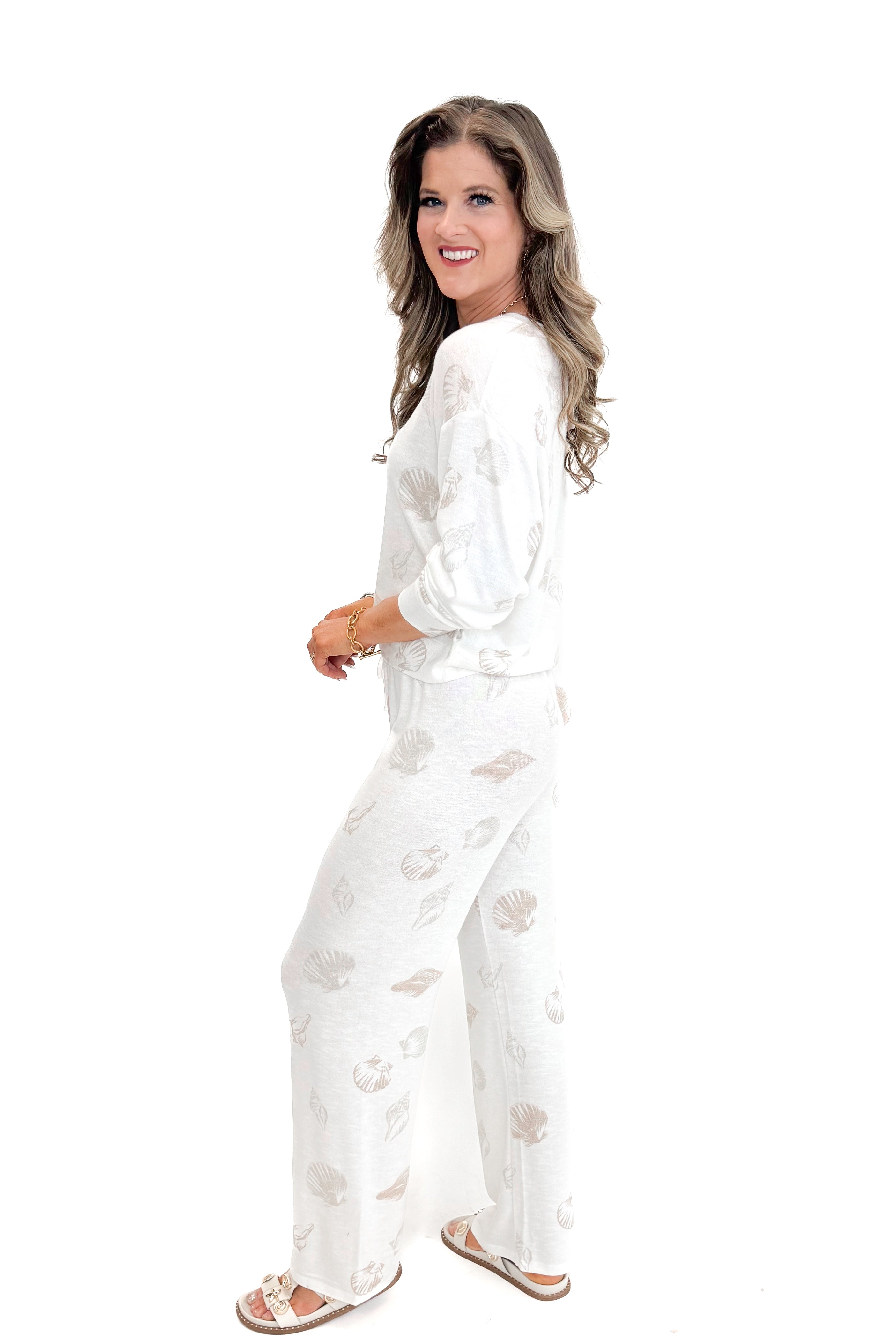 Side view of woman wearing Vanilla Ice So Sweet Shell Pants by Z Supply with matching top against white studio background.
