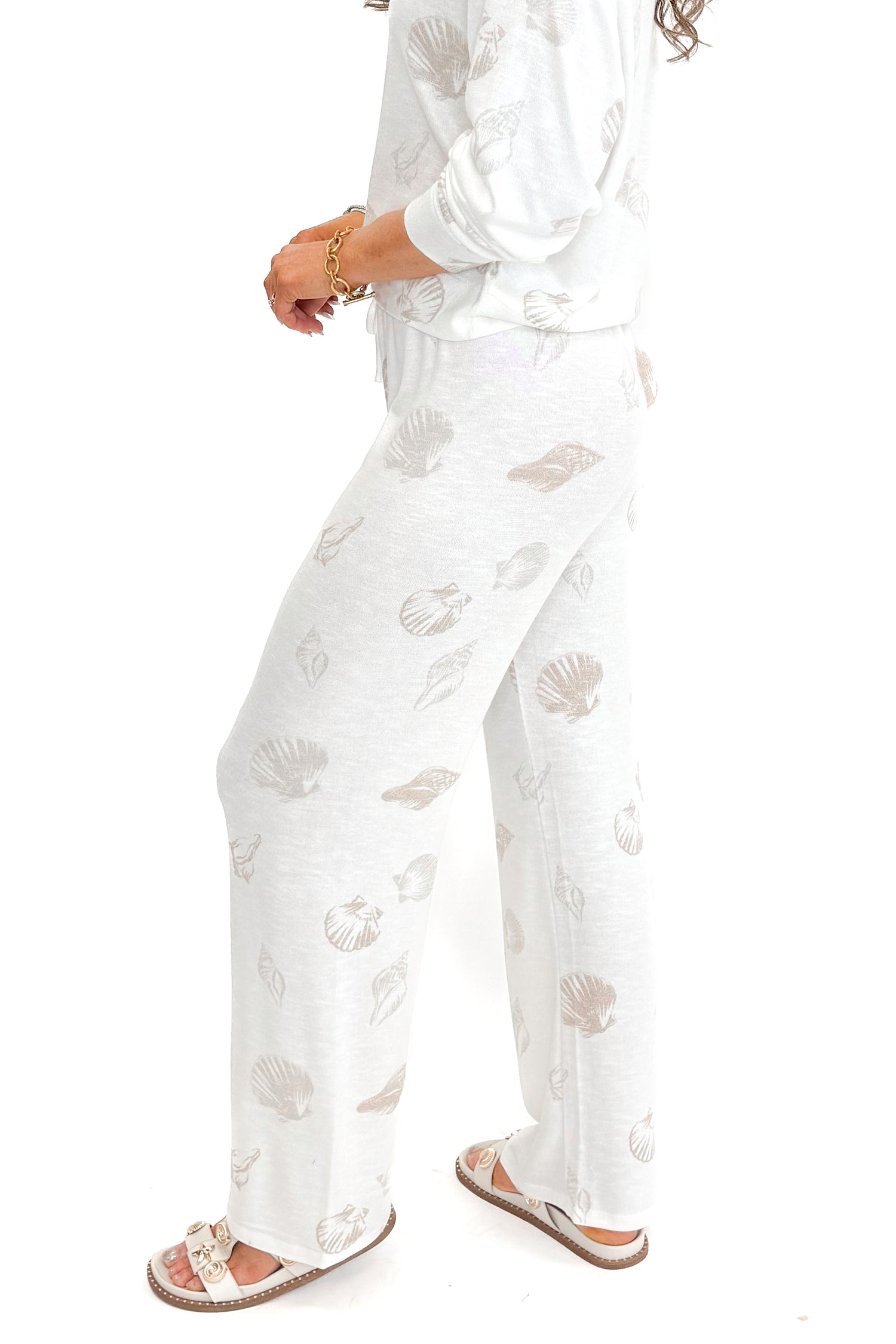 Side view of woman wearing Vanilla Ice So Sweet Shell Pants by Z Supply with matching top against white studio background.