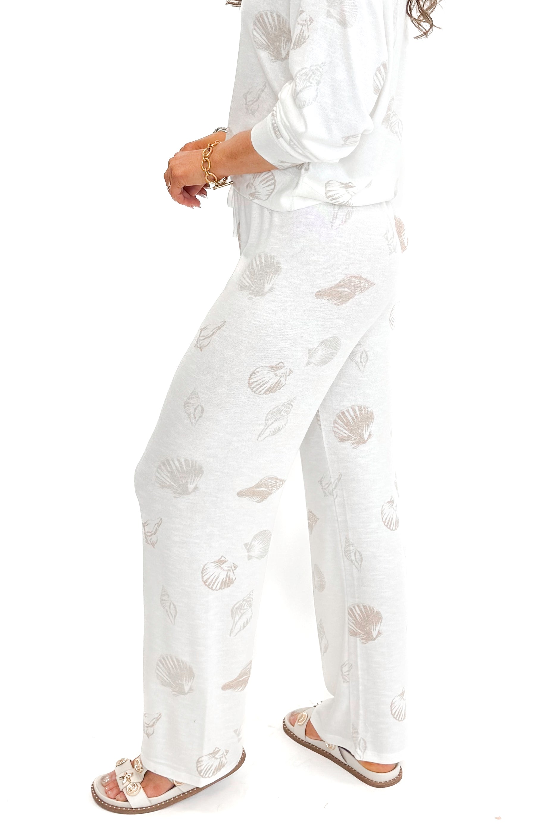 Side view of woman wearing Vanilla Ice So Sweet Shell Pants by Z Supply with matching top against white studio background.