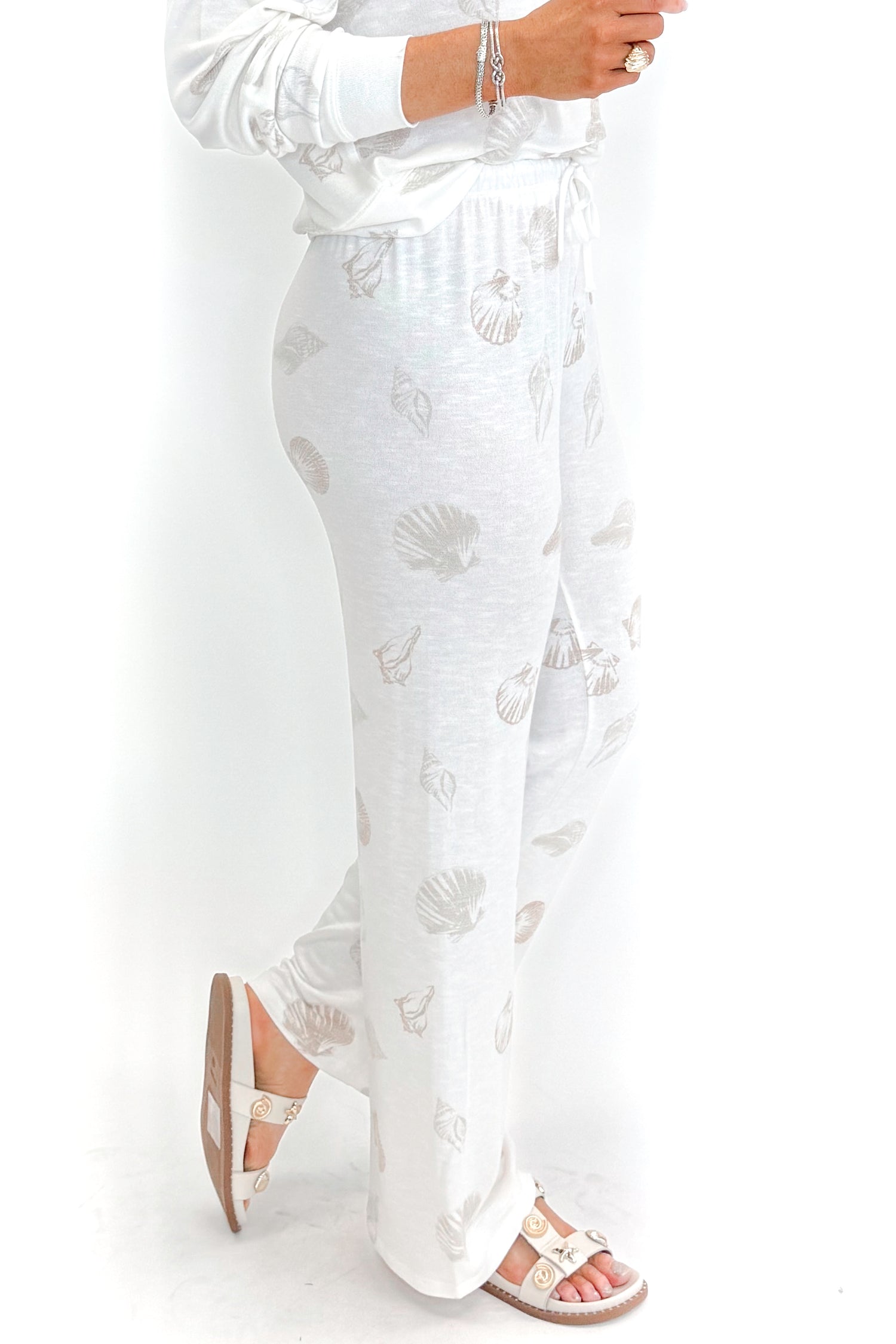 Side view of woman wearing Vanilla Ice So Sweet Shell Pants by Z Supply with matching top against white studio background.