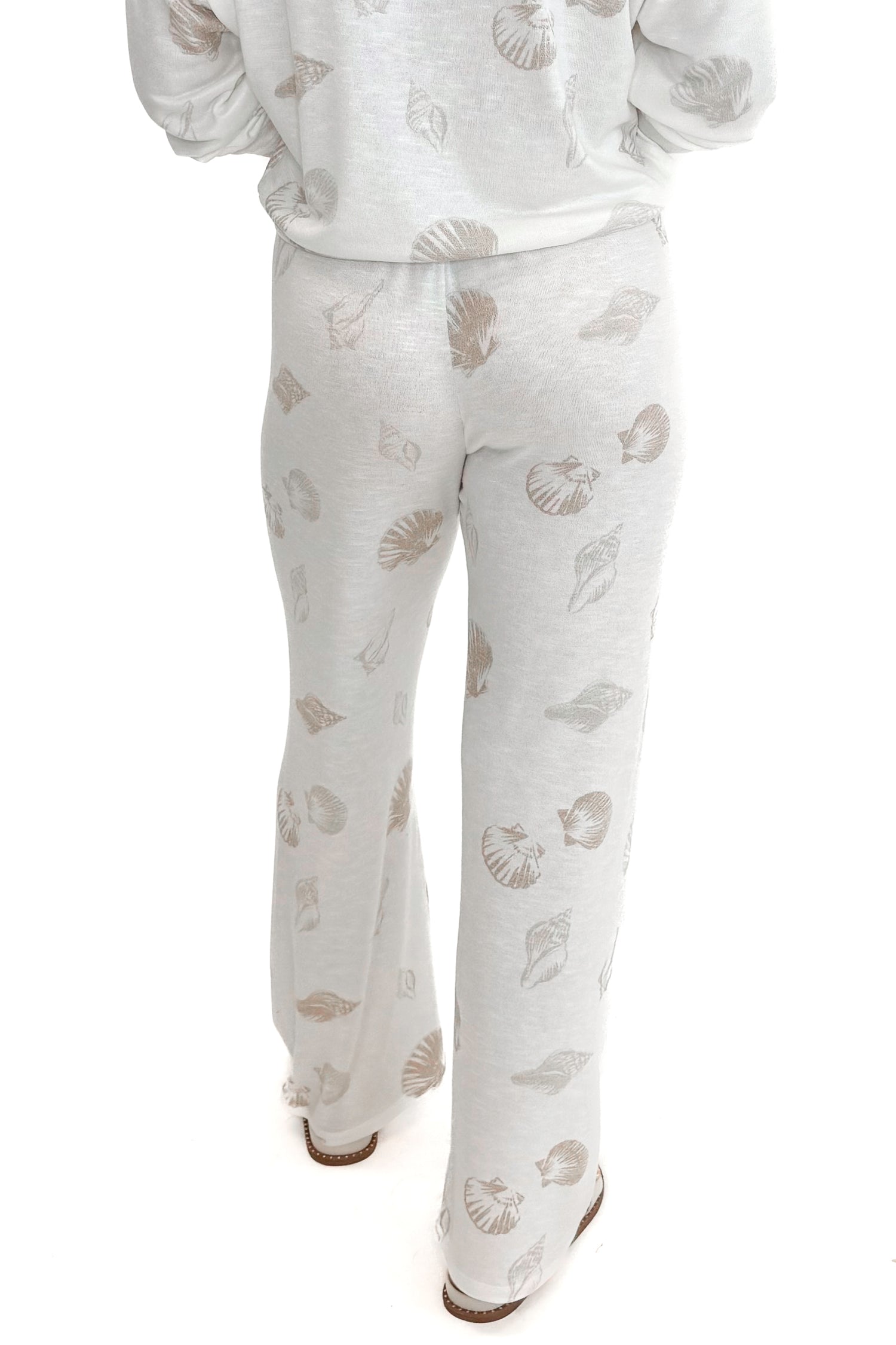 Back view of woman wearing Vanilla Ice So Sweet Shell Pants by Z Supply with matching top against white studio background.