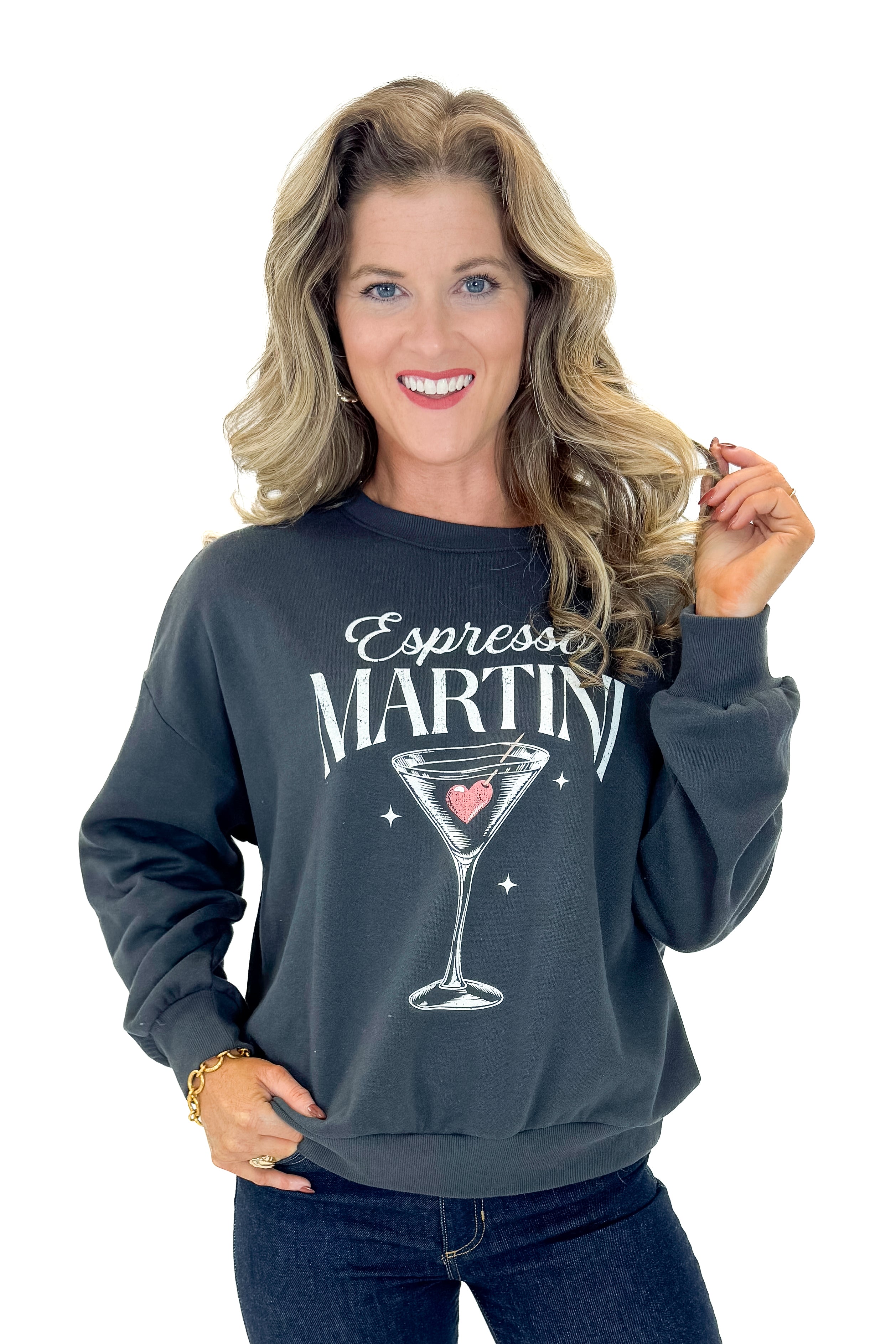 Front view of woman wearing Black Sand Oversized Martini Sweater with jeans against white studio background.