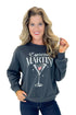 Front view of woman wearing Black Sand Oversized Martini Sweater with jeans against white studio background.