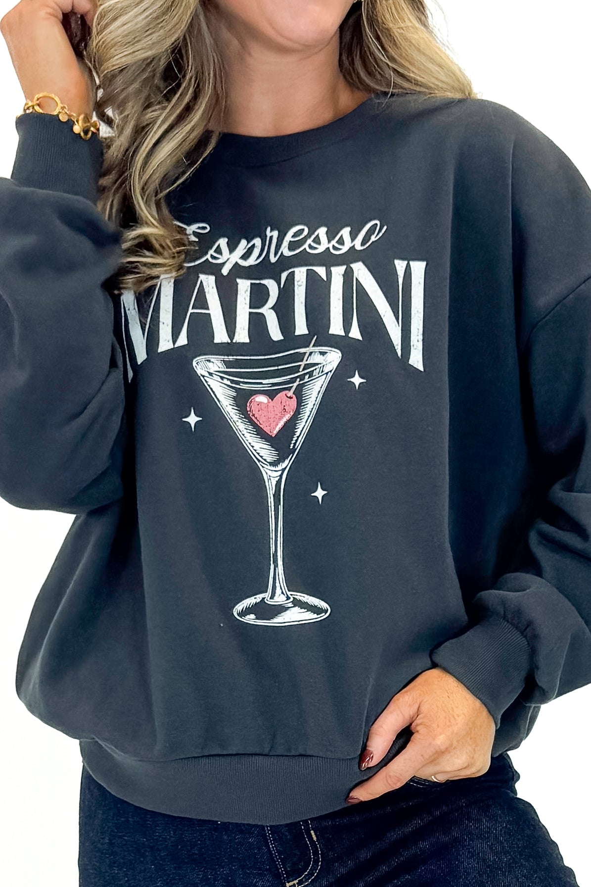 Front detailed view of woman wearing Black Sand Oversized Martini Sweater with jeans against white studio background.