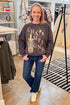 Front view of woman wearing Black Celebrate Sunday Sweatshirt with jeans at a boutique.