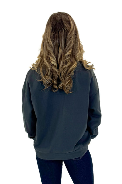 Back view of woman wearing Black Celebrate Sunday Sweatshirt with jeans against white studio background.