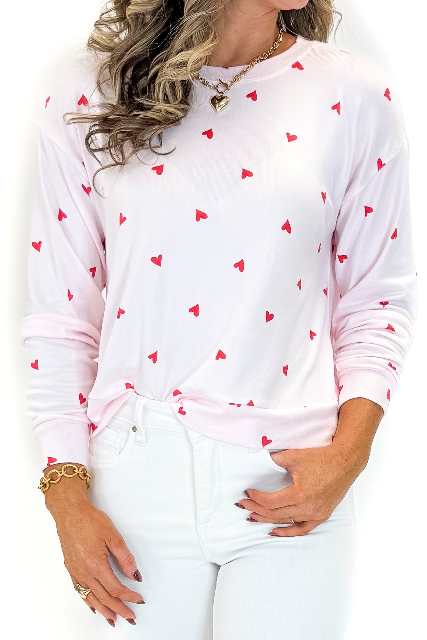 Front detail view of woman wearing Pink Marshmallow Mira Heart Top with jeans against white studio background.