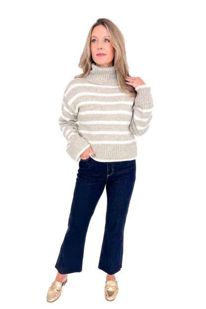 Front view of woman wearing Z Supply stripe Josephine sweater with jeans against white studio background.