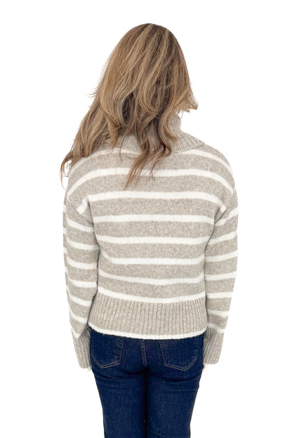 Back view of woman wearing Z Supply stripe Josephine sweater with jeans against white studio background.