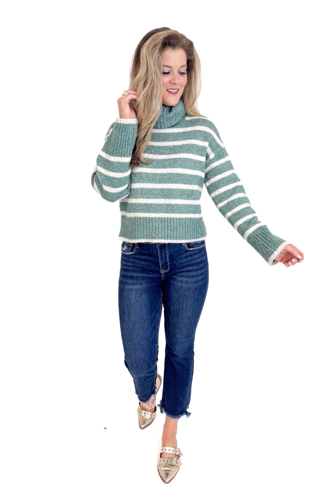 Woman wearing a striped sweater and jeans on a white background