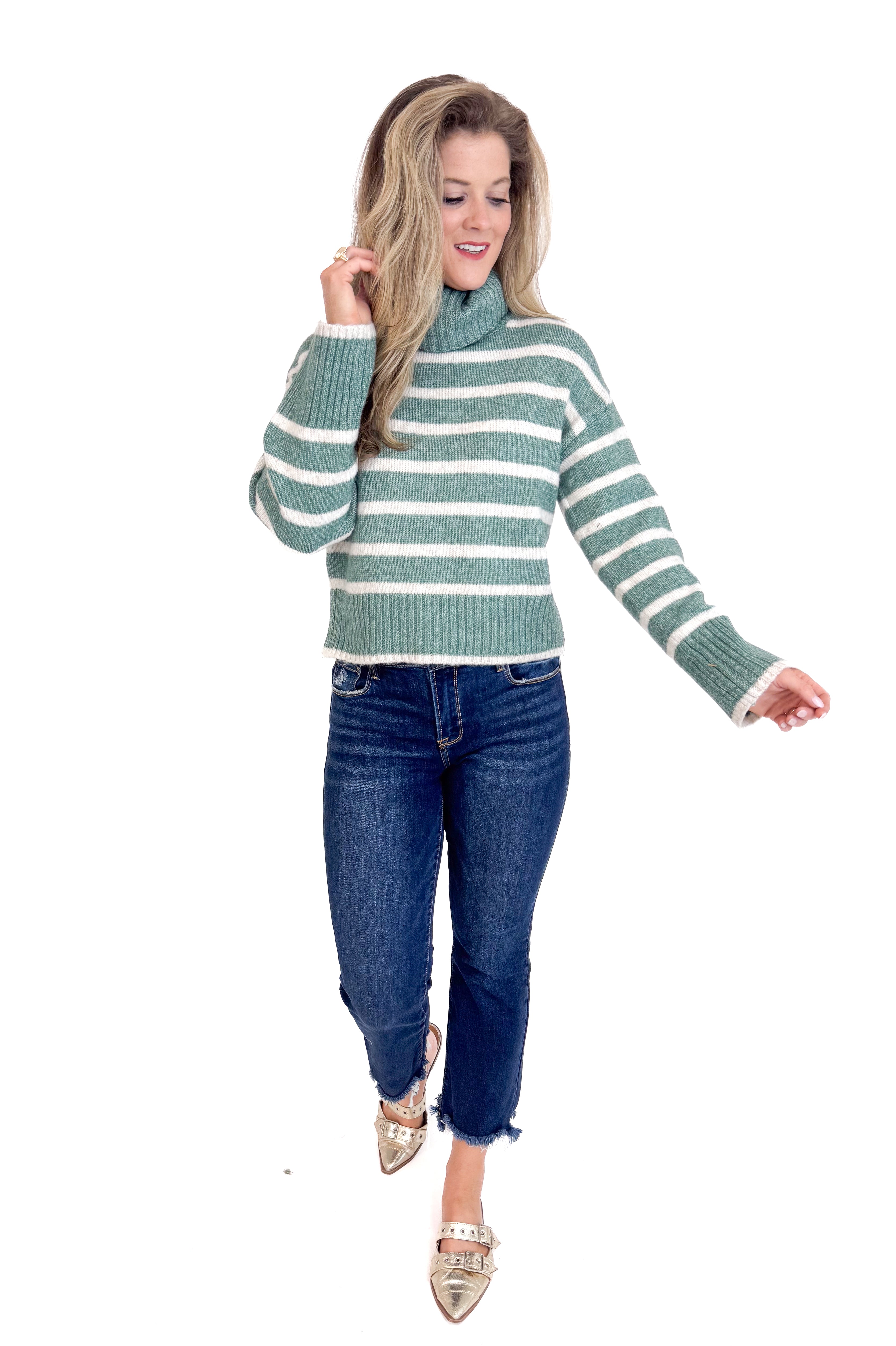 Woman wearing a striped sweater and jeans on a white background