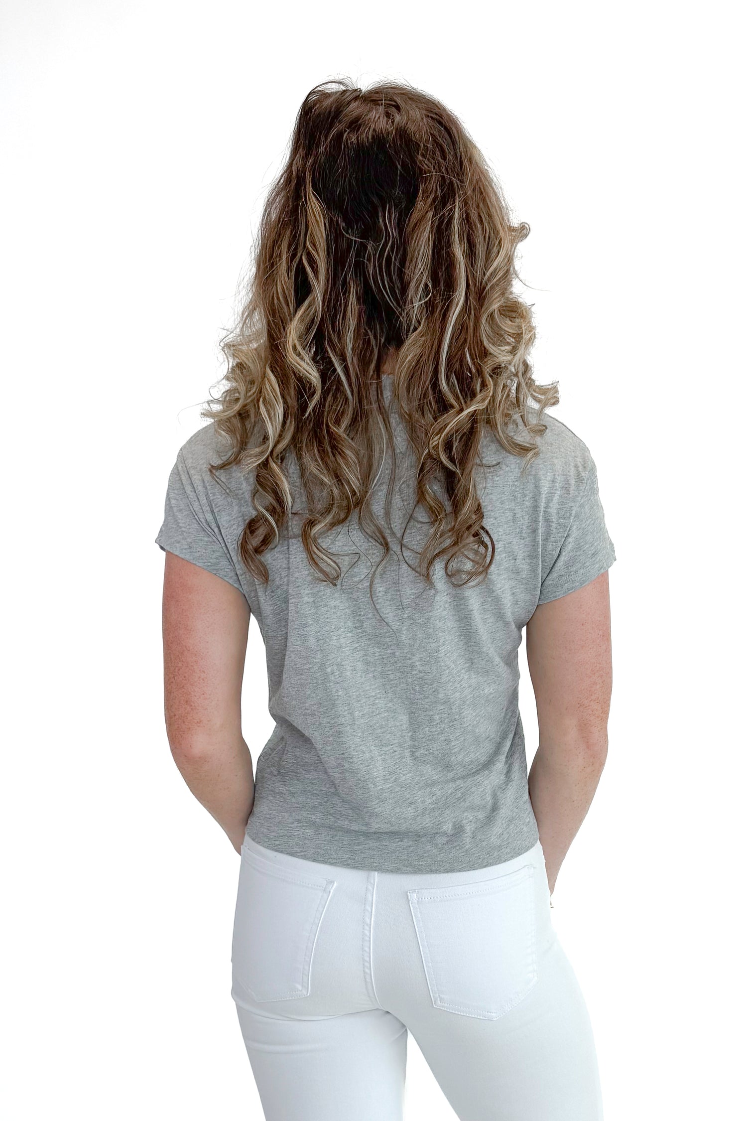 Back view of woman wearing Heather Grey Modern Slub Tee by Z Supply with jeans against white studio background.