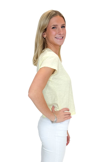 Side view of woman wearing Pineapple Modern Slub Tee by Z Supply with jeans against white studio background.