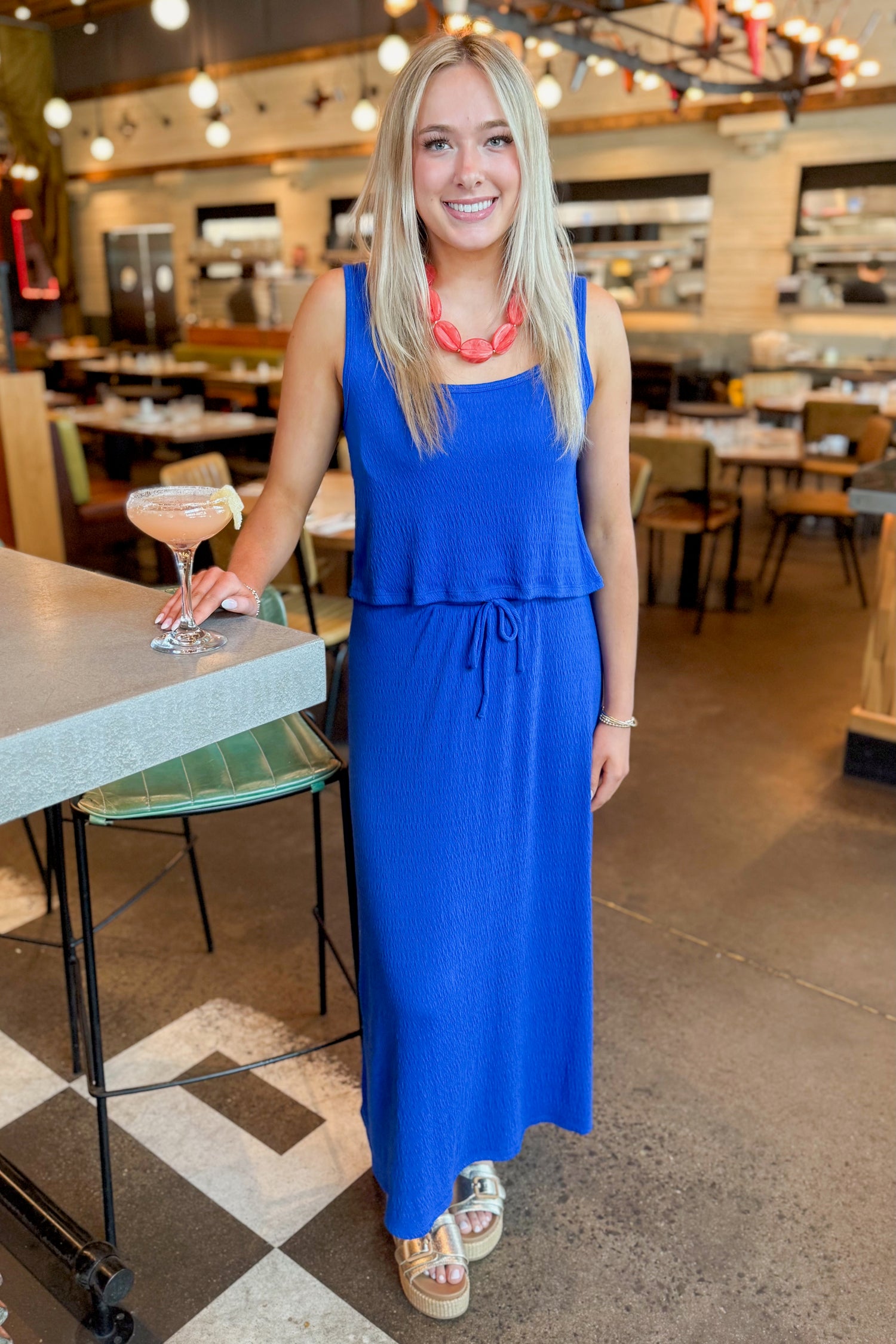 Front view of woman wearing Nautical Joanna Tank by Z Supply with matching skirt standing at a restaurant.