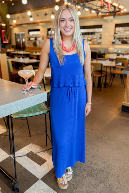 Front view of woman wearing Nautical Joanna Tank by Z Supply with matching skirt standing at a restaurant.