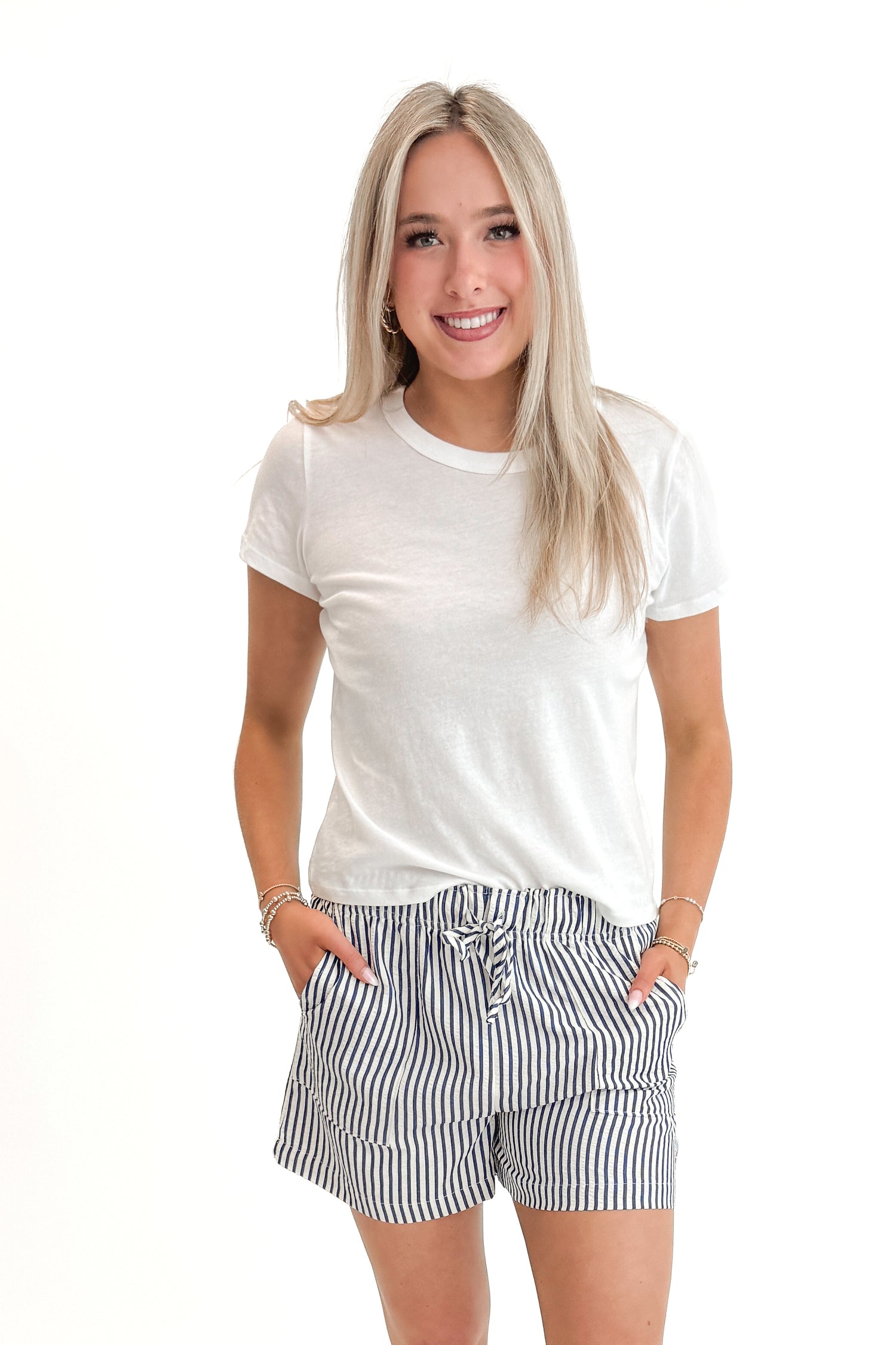 Front view of woman wearing White Junie Tee Shirt by Z Supply with pants against white studio background.